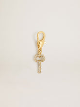 Key-shaped charm in gold-colored brass with crystals