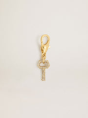 Key-shaped charm in gold-colored brass with crystals