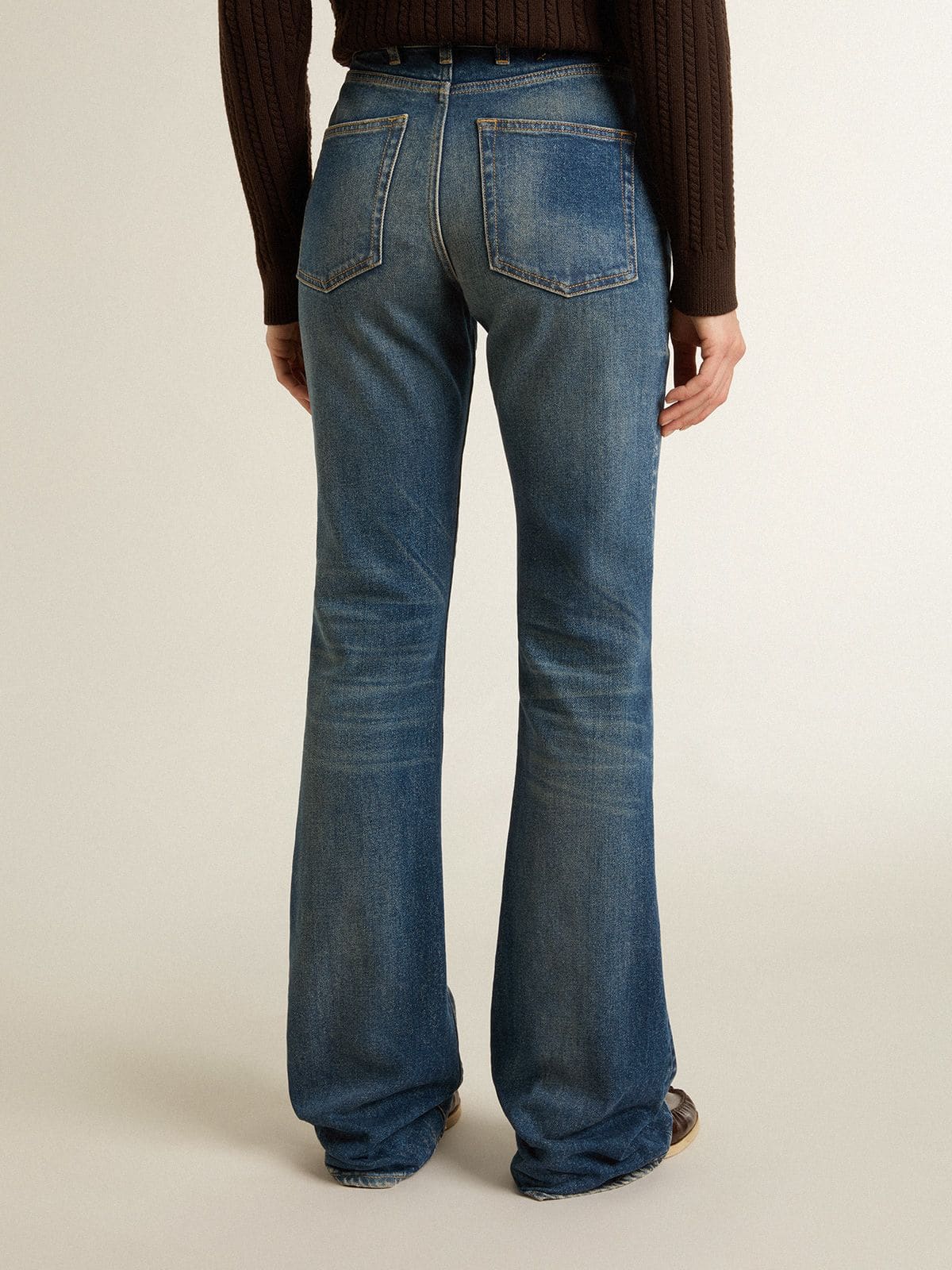 Women's bootcut jeans with a vintage wash and metallic details