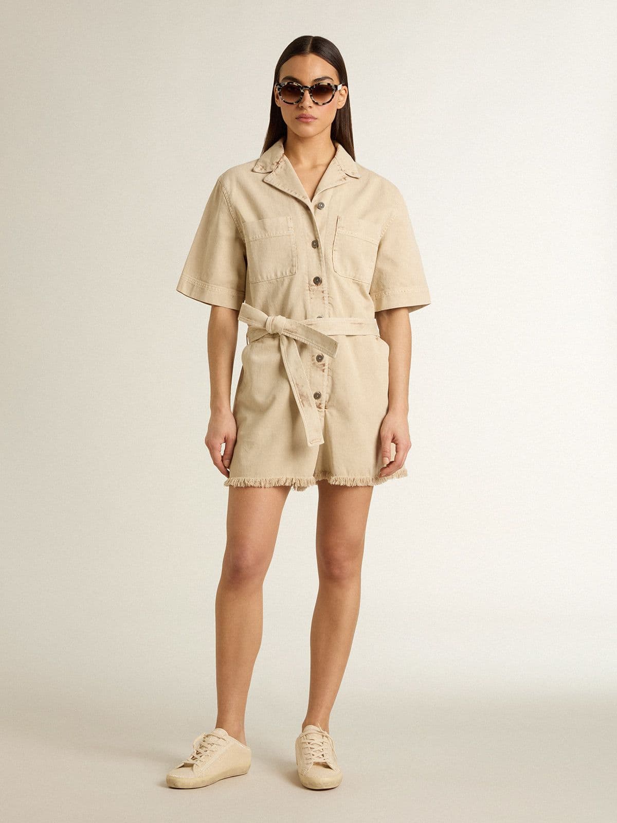 Women's romper in beige denim with belt and frayed hem