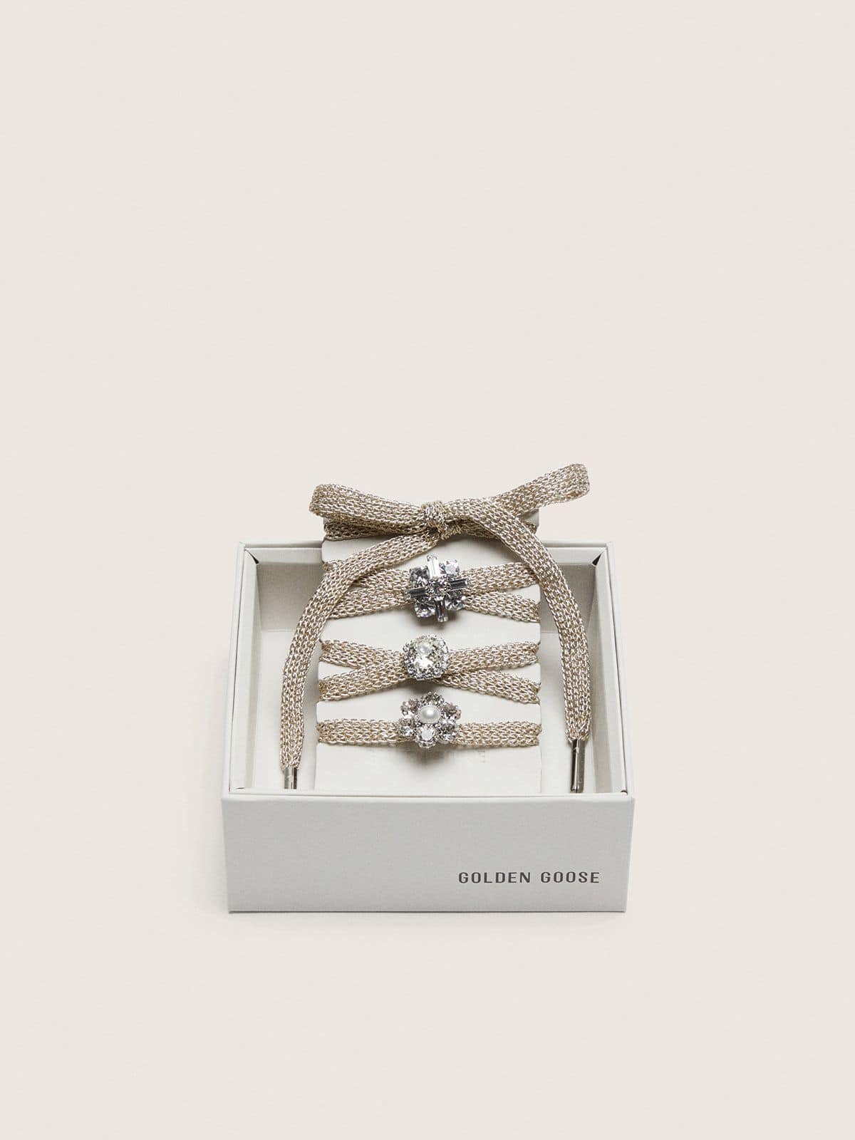 Skins braided gold-colored laces with shimmering charms