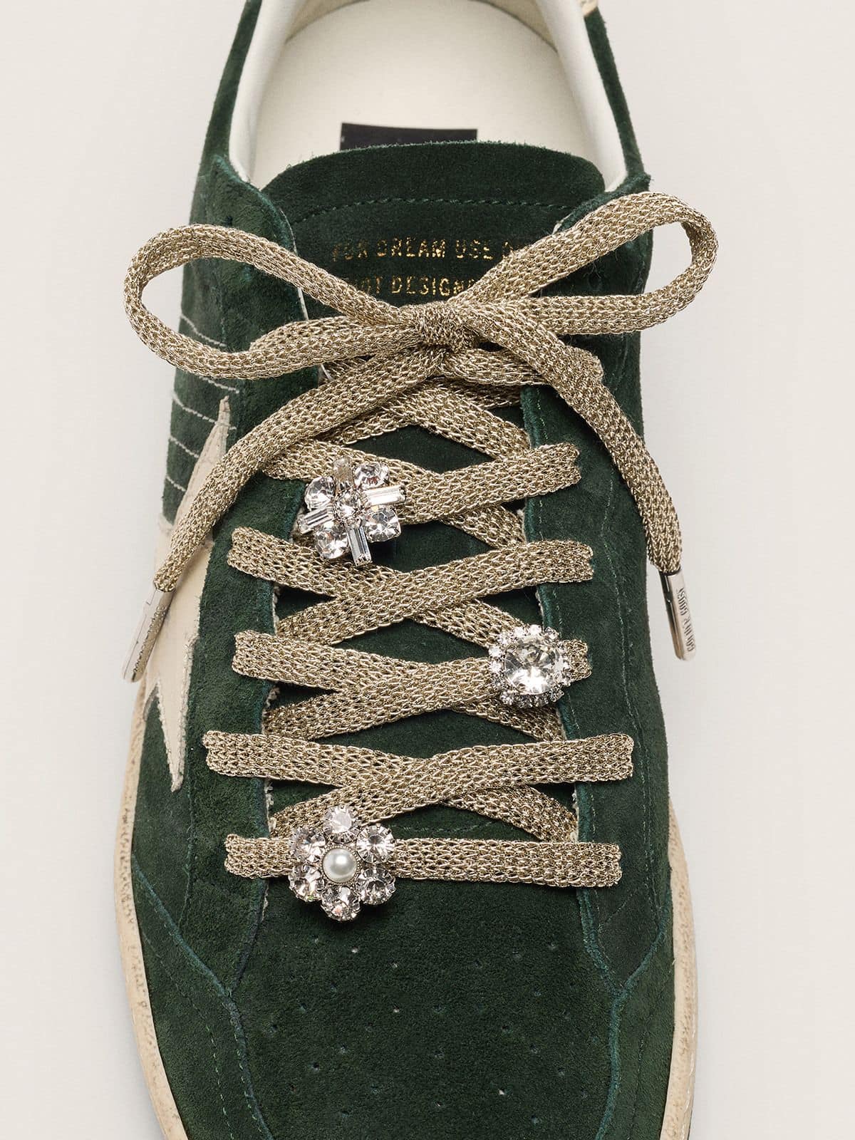 Skins braided gold-colored laces with shimmering charms