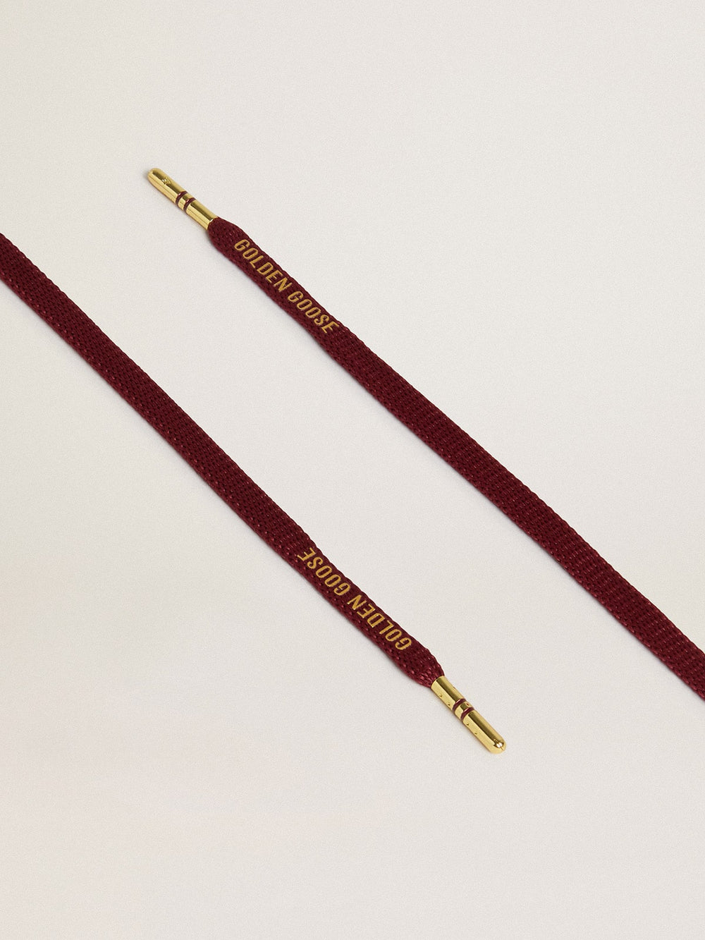 Burgundy cotton laces with contrasting gold-colored logo