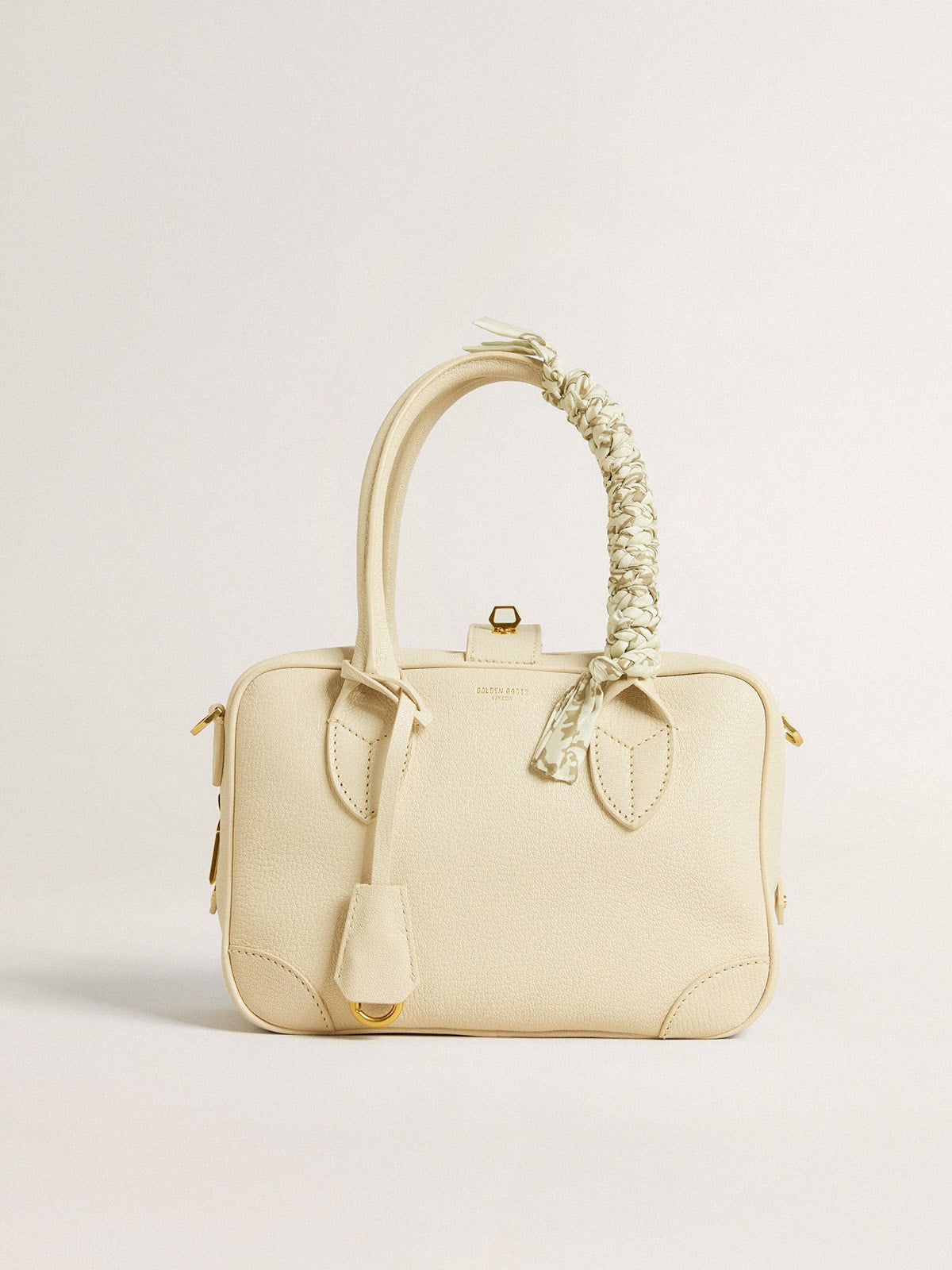 Butter-colored braided fabric charm with brass chain