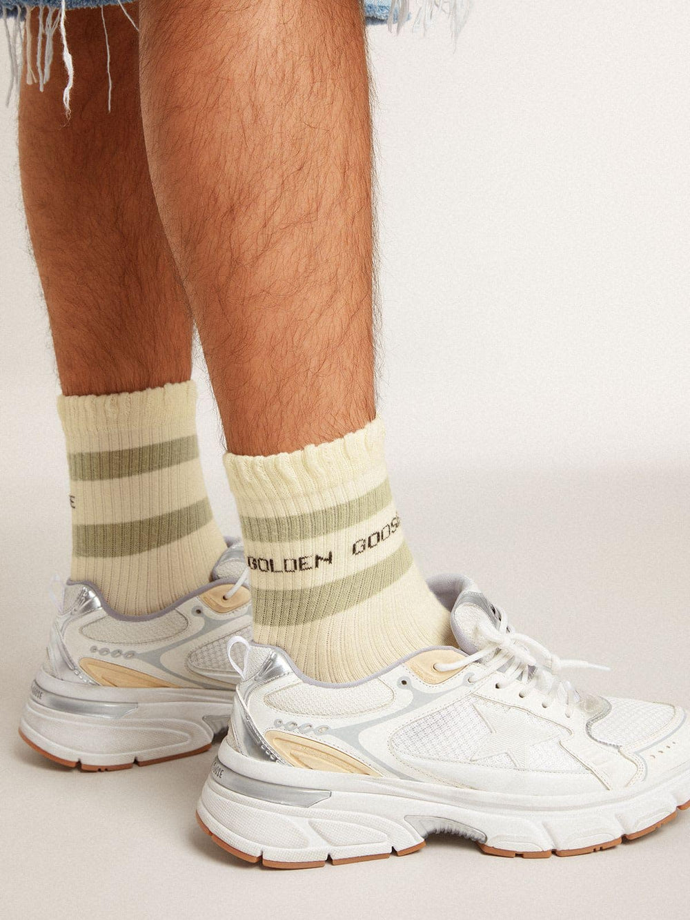 Worn-white socks with distressed details and sage-green stripes