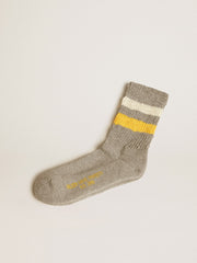 Gray socks with distressed details and yellow and white stripes