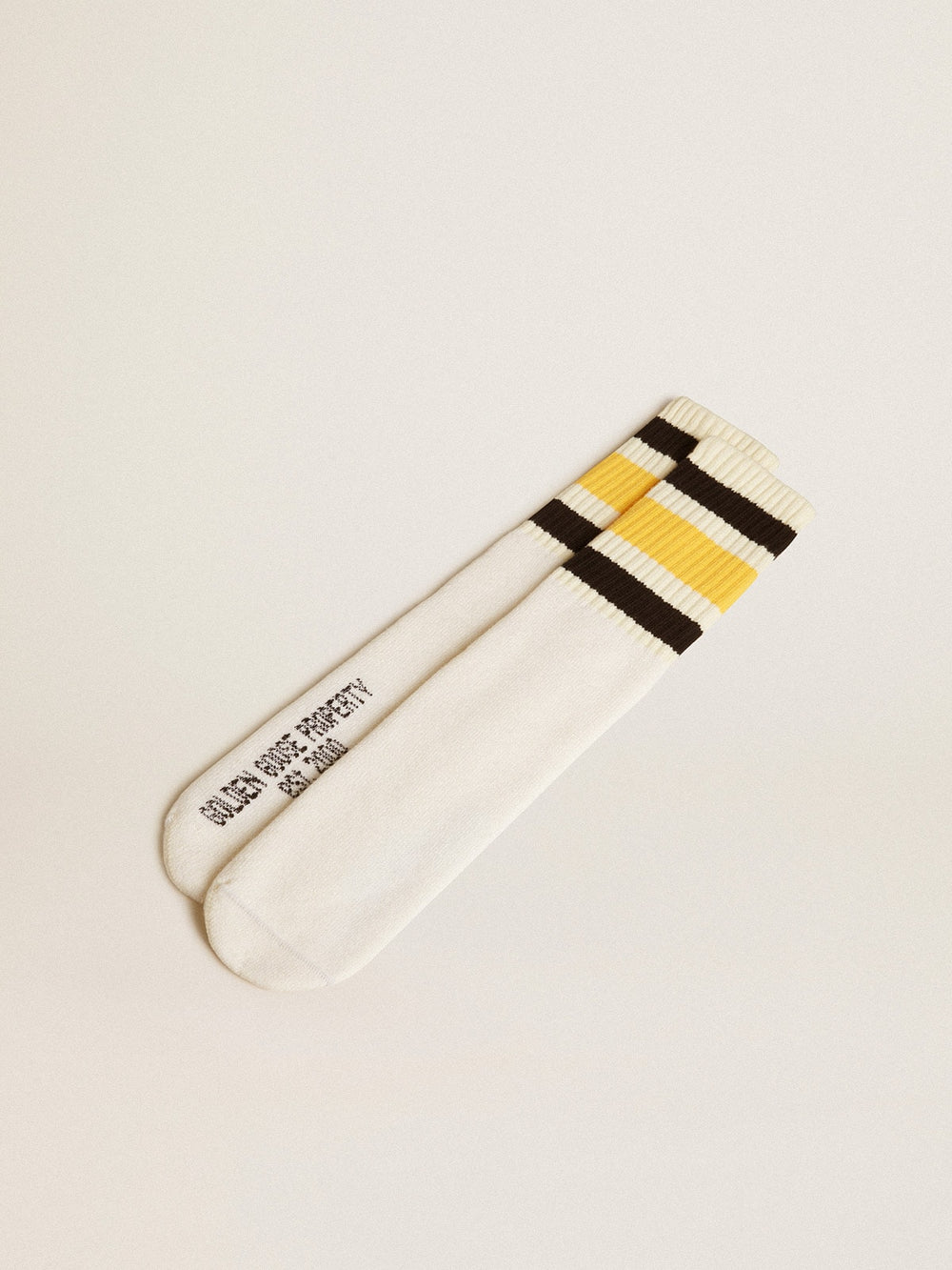Worn-white socks with distressed details and black and yellow stripes