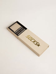 Dark grey socks with distressed details and cream and worn-white stripes