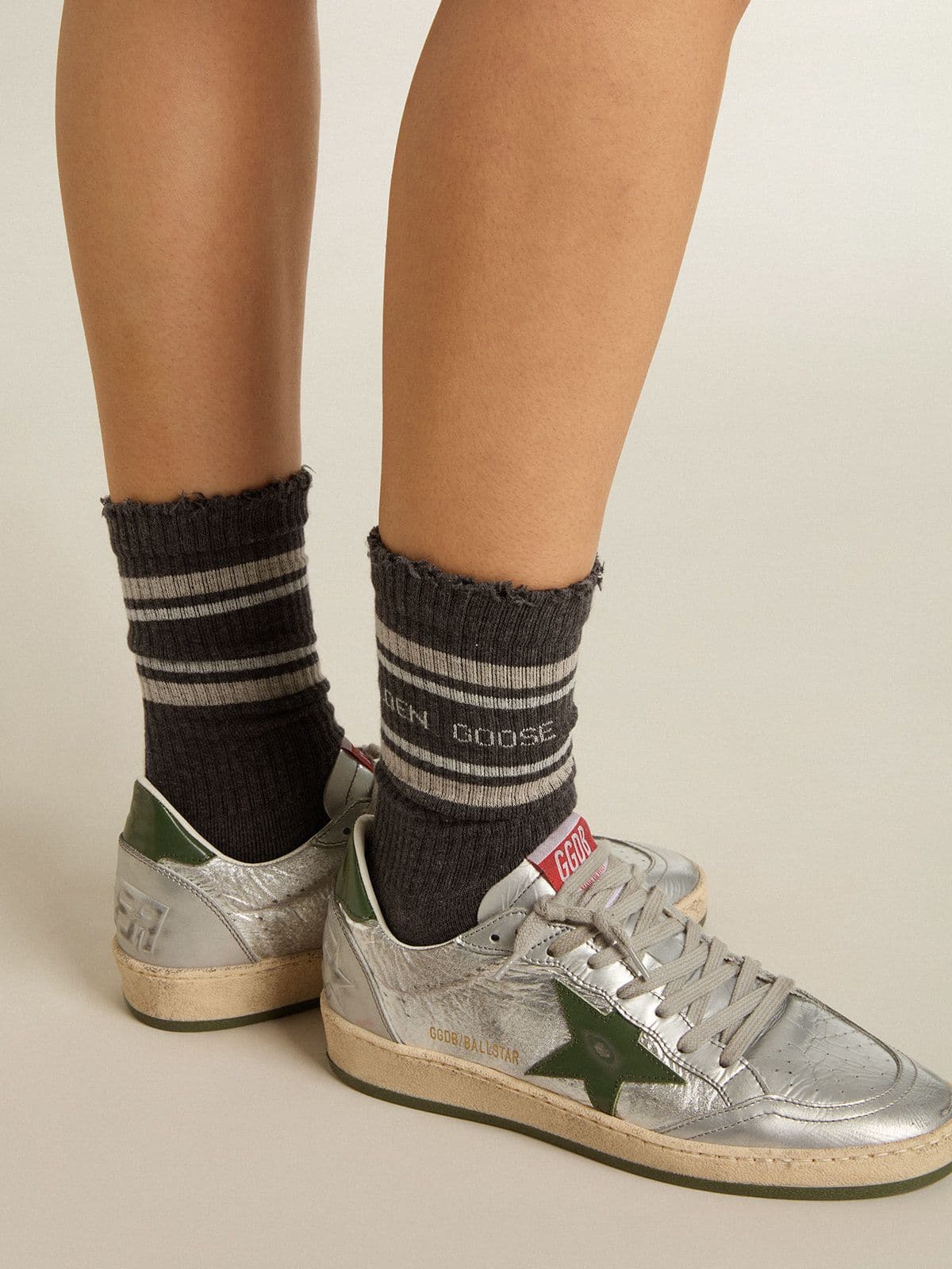 Dark grey socks with distressed details and cream and worn-white stripes