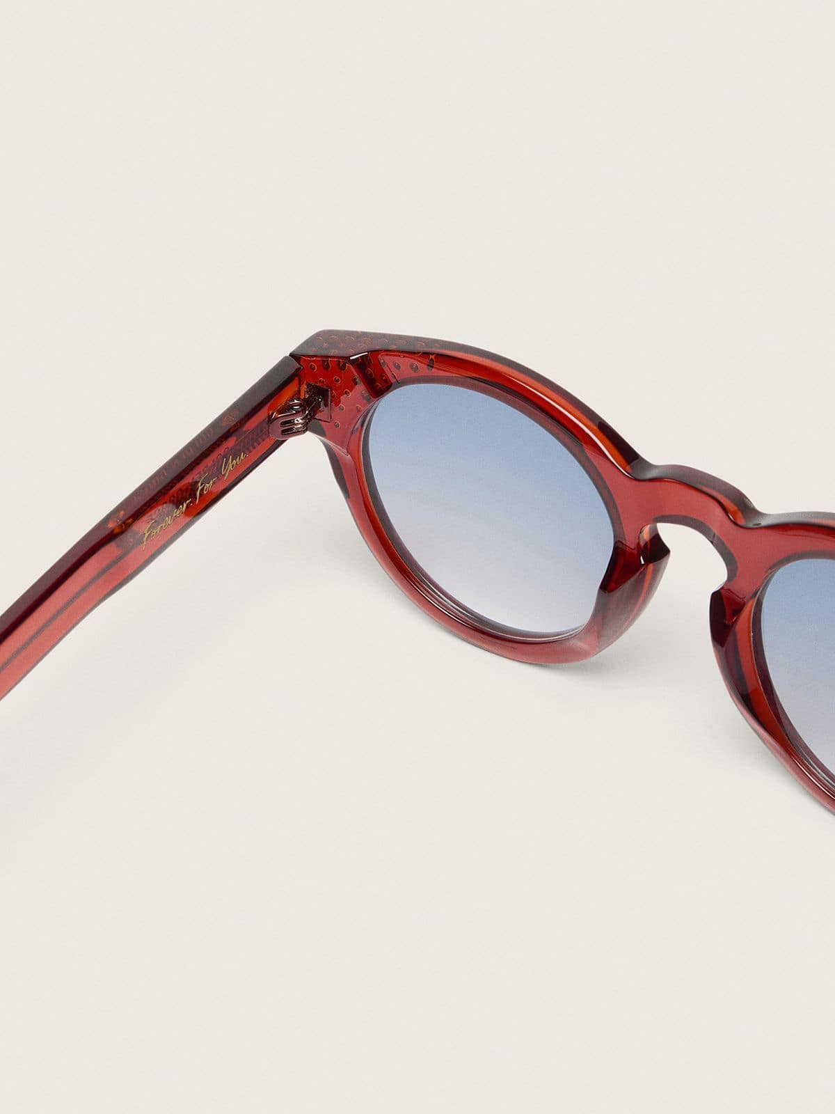 precious stones and blue lenses Cameron Panthos sunglasses with honey frame