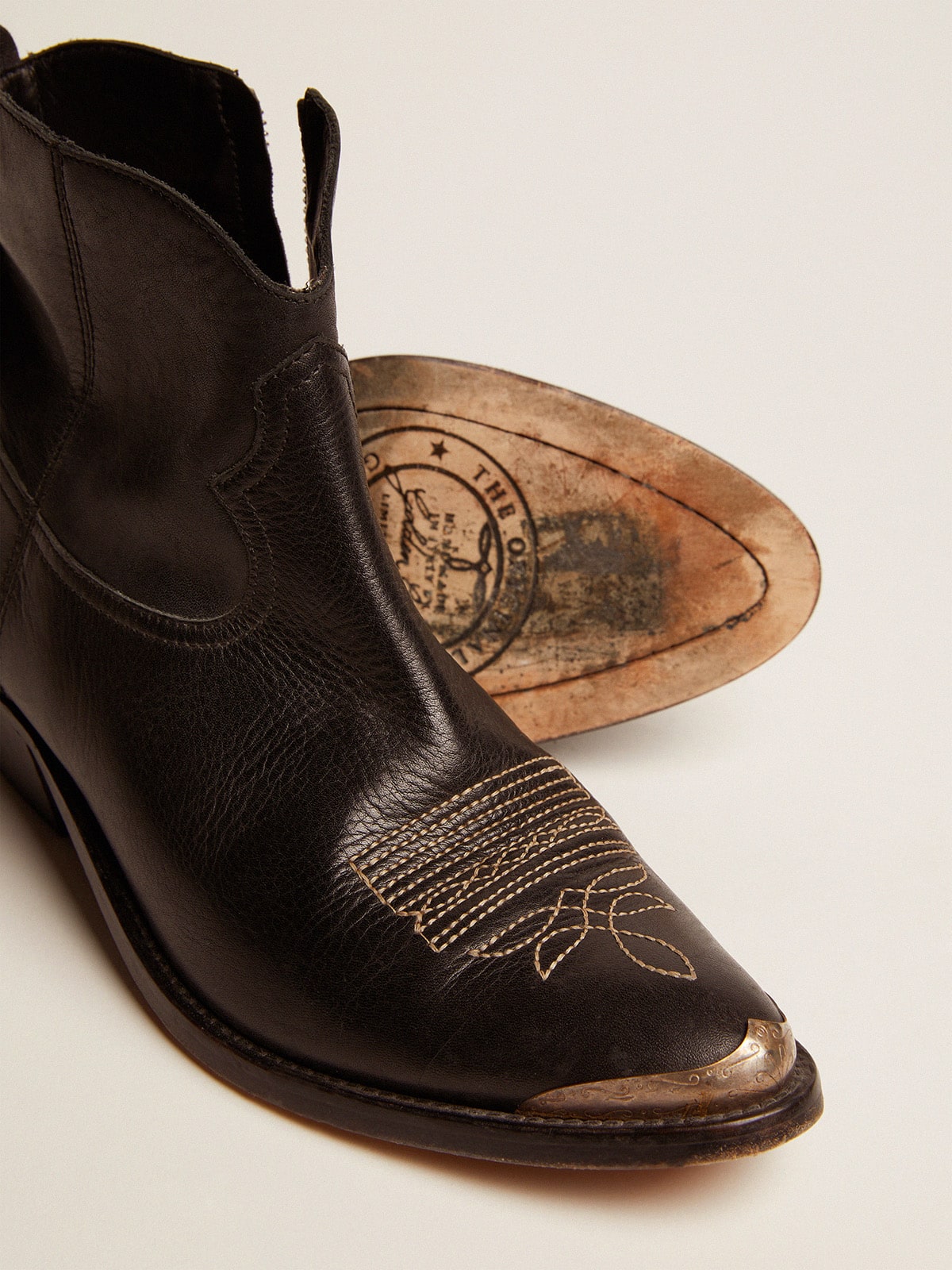 Young ankle boots in black leather with sand-colored embroidery