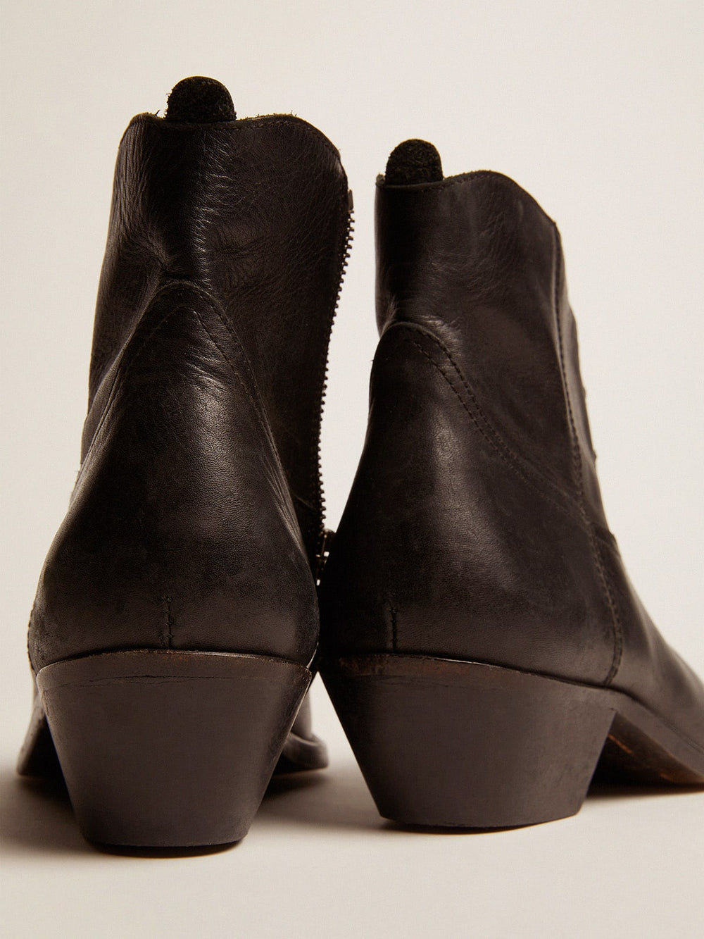 Young ankle boots in black leather with sand-colored embroidery