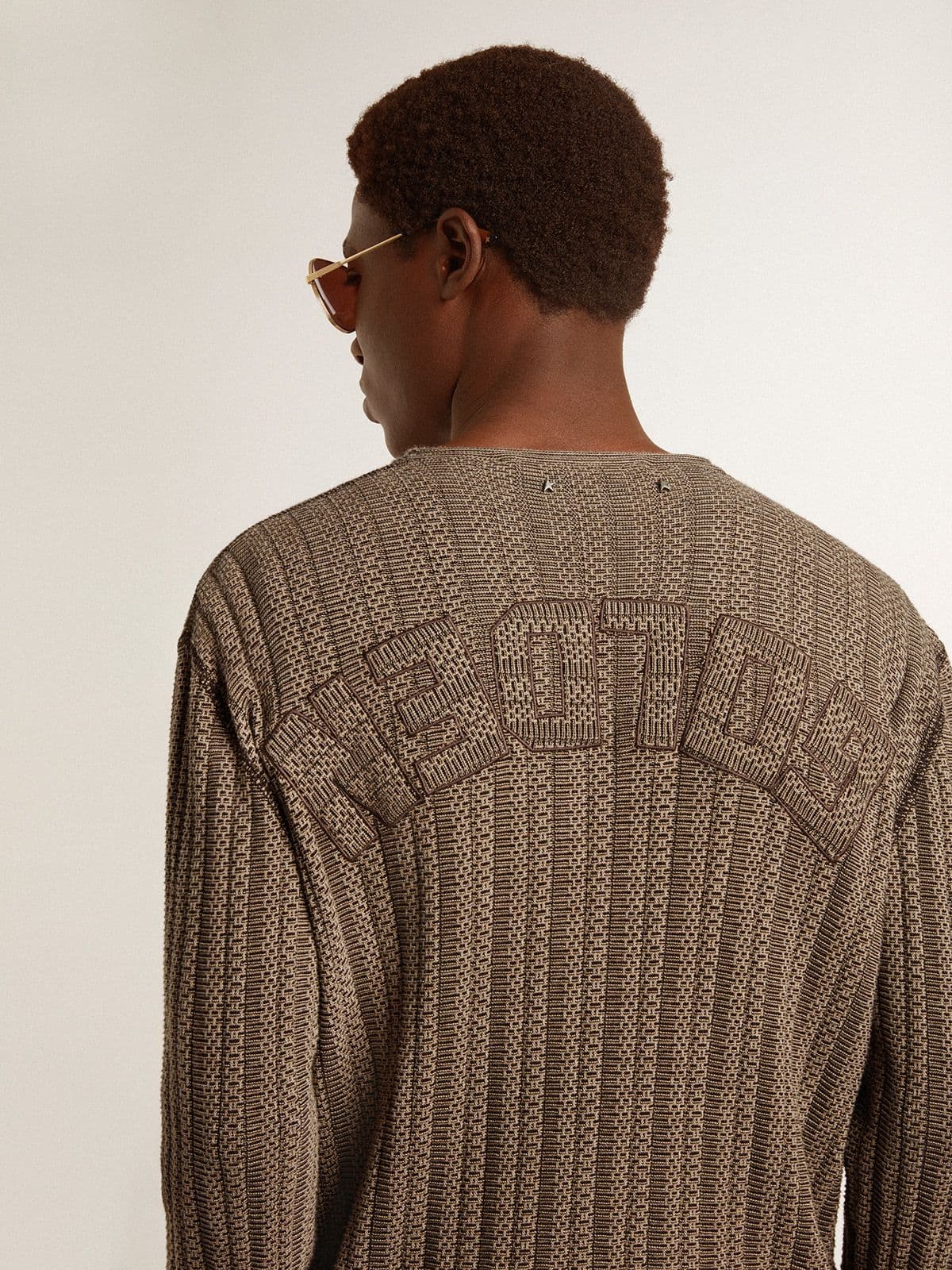 Men's travertine-colored sweater with 'Golden' patch lettering on the back