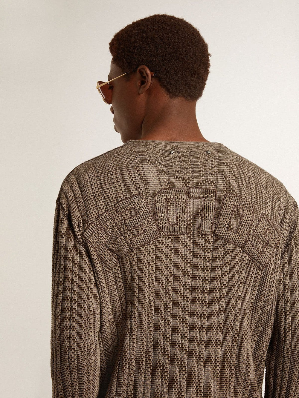 Men's travertine-colored sweater with 'Golden' patch lettering on the back