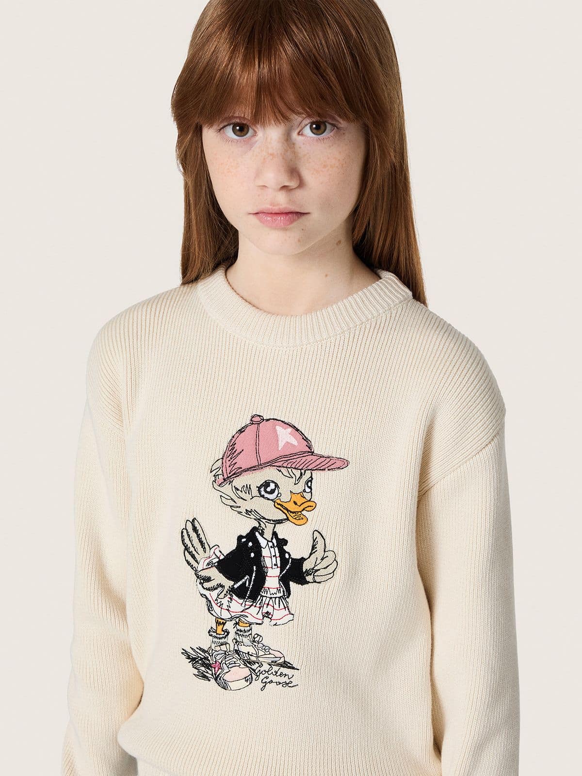 Golden girls’ sweater in white cotton yarn with mascot embroidery
