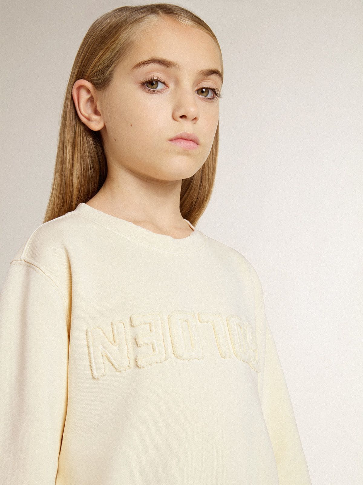 Girls’ cream-colored sweatshirt with patch writing