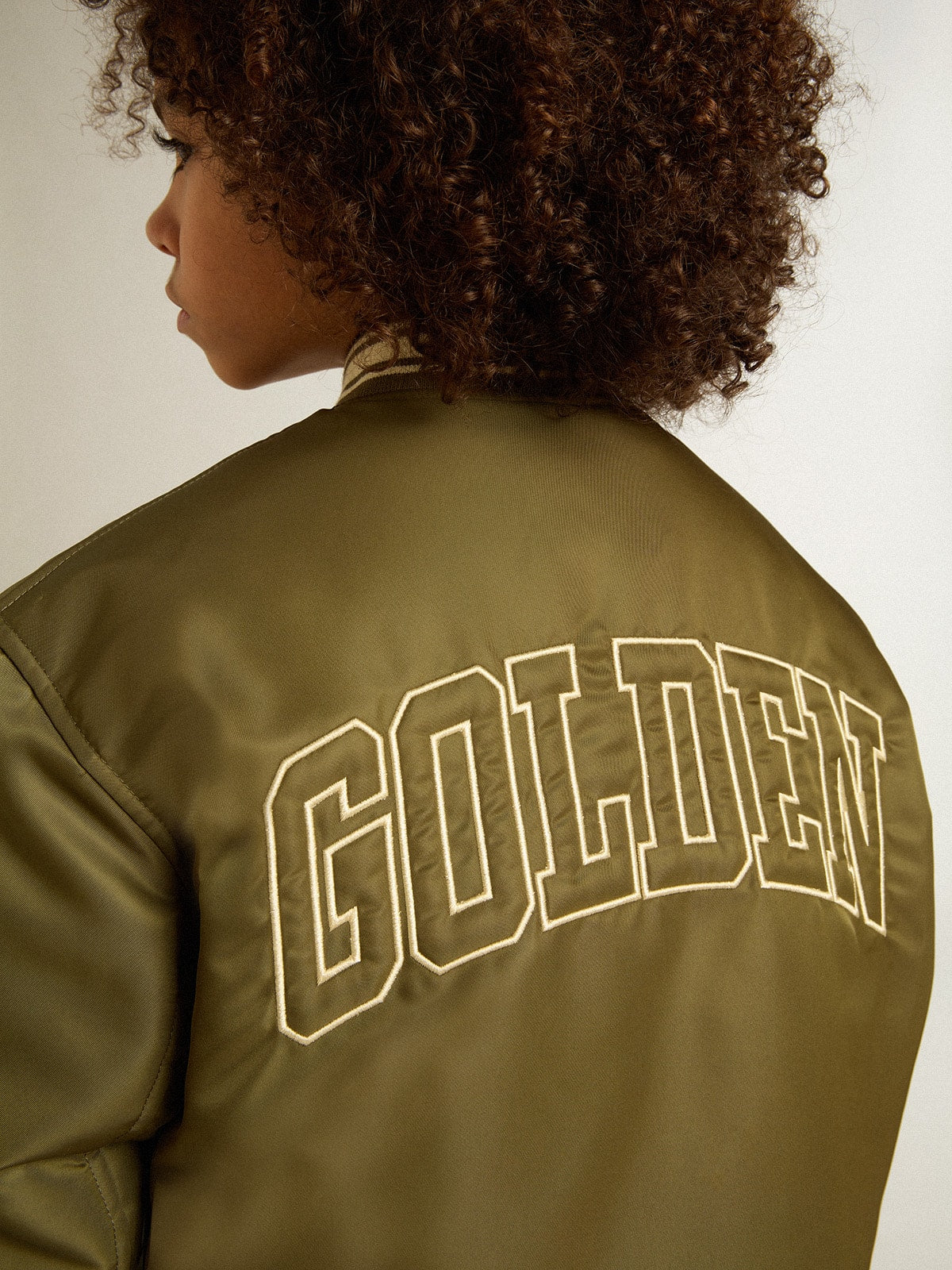 Kids military-green nylon bomber jacket with lettering on the back