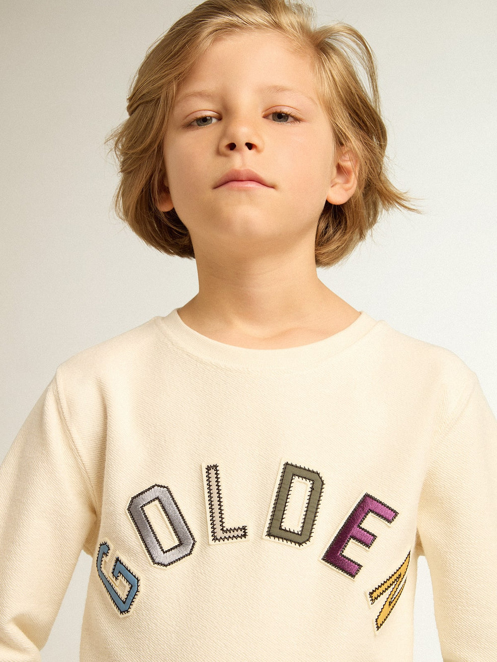Sweatshirt in aged white with multicolor Golden lettering on the front